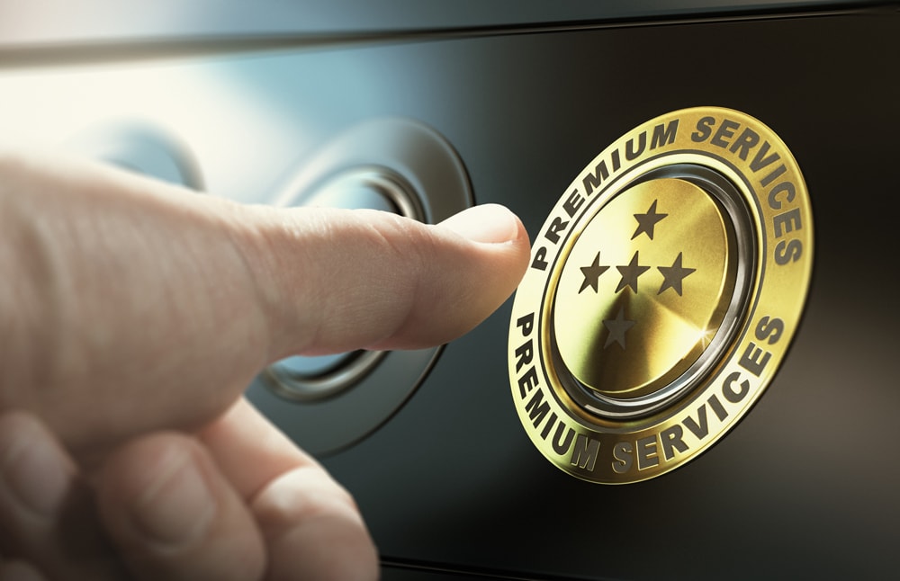 image d'un bouton avec écrit au tour "service premium" sur lequel le pouce d'une personne s'apprête à appuyer